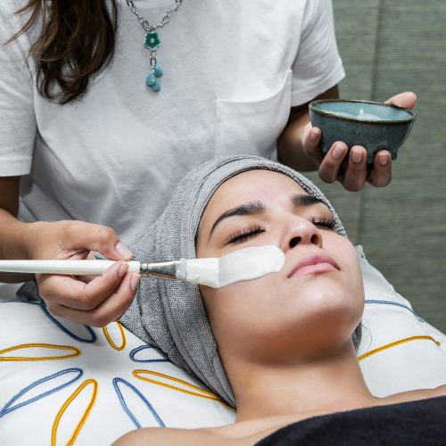 Woman enjoying facial treatment in salon